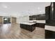 Open kitchen with dark cabinets, a center island and a view of the outdoor patio at 234 Polaris Ridge Ave, Henderson, NV 89011