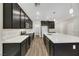 Bright kitchen with dark cabinets, an island, a pantry, and stainless steel appliances at 234 Polaris Ridge Ave, Henderson, NV 89011