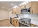 Well-equipped kitchen with stainless steel appliances, wood cabinets, and quartz countertops at 2606 S Durango Dr # 117, Las Vegas, NV 89117
