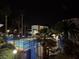 Nighttime view of a community pool surrounded by palm trees and a secure fence, creating a relaxing ambiance at 2637 Red Rock St # 202, Las Vegas, NV 89146
