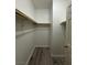 Spacious walk-in closet with wood laminate flooring, wooden shelf and white wall at 2637 Red Rock St # 202, Las Vegas, NV 89146