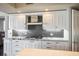 Gourmet kitchen features custom white cabinets, granite counters, and tile backsplash at 2777 Paradise Rd # 1701, Las Vegas, NV 89109