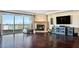 Open-concept living room with hardwood floors, fireplace, large TV, and sliding glass doors with city views at 2777 Paradise Rd # 1701, Las Vegas, NV 89109