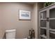 Powder room featuring a toilet, unique lantern decor, boat artwork, and an accent cabinet with glass doors at 2777 Paradise Rd # 1701, Las Vegas, NV 89109