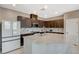 Updated kitchen boasts granite countertops, stainless steel appliances, dark wood cabinets, and tiled flooring at 2853 Cabrillo Terrace St, Henderson, NV 89044