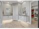 Modern bathroom featuring dual sinks, vanity, tiled walls, and entry to the walk-in closet with ample shelving at 2910 Raywood Ash Dr, Las Vegas, NV 89138