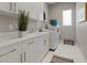 Laundry room featuring modern white cabinets, countertops, washing machine, and a window at 2910 Raywood Ash Dr, Las Vegas, NV 89138
