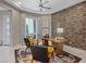 Chic office space with a brick accent wall, neutral colors, and lots of natural light from a window at 2910 Raywood Ash Dr, Las Vegas, NV 89138
