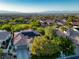 Suburban homes showcase tile roofs, solar panels, and lush trees, offering stunning mountain views in the distance at 2964 Via Della Amore, Henderson, NV 89052