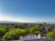Panoramic view from a home's rooftop deck overlooking neighborhood, trees, and distant mountains at 2964 Via Della Amore, Henderson, NV 89052
