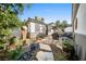 Charming backyard oasis with stone pathways, lush landscaping, and relaxing seating areas at 2964 Via Della Amore, Henderson, NV 89052