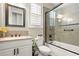Bathroom featuring a shower and tub combo with glass doors, a white toilet, and a black framed mirror at 2964 Via Della Amore, Henderson, NV 89052