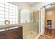 Beautiful bathroom with a glass enclosed shower, glass block window and granite countertops on the vanity at 2964 Via Della Amore, Henderson, NV 89052