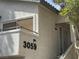 Close-up view of a condo exterior featuring a balcony, private entrance, and modern lighting fixtures at 3059 Key Largo Dr # 203, Las Vegas, NV 89120