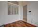 A room with white walls, wood floors, a window with white shutters, and a partial view of an adjacent room at 3200 Ridgecliff St, Las Vegas, NV 89129