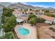 Aerial view of a kidney-shaped pool with surrounding patio and desert landscaping, adjacent to a covered area at 3200 Ridgecliff St, Las Vegas, NV 89129