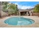 In-ground pool surrounded by hardscape, shrubs, trees, and a perimeter brick wall at 3200 Ridgecliff St, Las Vegas, NV 89129