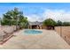In-ground pool surrounded by hardscape, shrubs, trees, and a perimeter brick wall at 3200 Ridgecliff St, Las Vegas, NV 89129