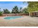 In-ground pool surrounded by hardscape, shrubs, trees, and a perimeter brick wall at 3200 Ridgecliff St, Las Vegas, NV 89129