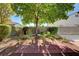 Inviting backyard with garden landscaping and a charming bistro set under a shade tree at 3913 Cutting Horse Ave, North Las Vegas, NV 89032