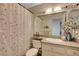 Bathroom featuring a floral shower curtain, granite counters and decorative details at 3913 Cutting Horse Ave, North Las Vegas, NV 89032