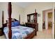 Cozy bedroom with a wooden four-poster bed and a window for natural light at 3913 Cutting Horse Ave, North Las Vegas, NV 89032