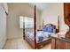 Cozy bedroom with a wooden four-poster bed and a window for natural light at 3913 Cutting Horse Ave, North Las Vegas, NV 89032