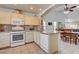 Well-lit kitchen with granite countertops and backsplash, white appliances, and tile flooring at 3913 Cutting Horse Ave, North Las Vegas, NV 89032