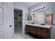 Bathroom with a double sink vanity, large mirror and walk-in closet at 3953 Broad Meadow Ct, Las Vegas, NV 89129