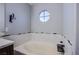 A bathroom showcasing a soaking tub with decorative tile surround and unique circular window at 3953 Broad Meadow Ct, Las Vegas, NV 89129