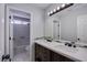 Bathroom with a double sink vanity, large mirror and tiled floors and walls at 3953 Broad Meadow Ct, Las Vegas, NV 89129