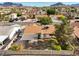 Aerial view of a well-maintained backyard with a patio cover, bordered by mature trees and a sturdy block wall at 423 Golden Valley Dr, Henderson, NV 89002