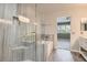 Modern bathroom featuring a glass-enclosed shower, separate tub and marble tile at 423 Red Canvas Pl, Las Vegas, NV 89144