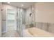 Elegant bathroom with a walk-in shower, soaking tub, and access to a walk-in closet at 423 Red Canvas Pl, Las Vegas, NV 89144
