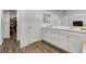 Bathroom features a double sink vanity with white cabinets and wood-look flooring at 5016 Kaslo Ave, Las Vegas, NV 89139