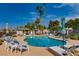Inviting community pool area with lounge chairs, palm trees, and clear blue water at 5044 Signal Dr, Las Vegas, NV 89130