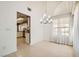 Dining area featuring elegant chandelier, large window, and neutral tones at 5044 Signal Dr, Las Vegas, NV 89130