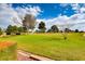 Manicured green lawn with mature trees and fountain at 5044 Signal Dr, Las Vegas, NV 89130