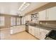 Spacious kitchen with granite countertops, white cabinets, and a stainless steel dishwasher at 5044 Signal Dr, Las Vegas, NV 89130