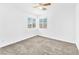 Bright bedroom featuring neutral carpet, a ceiling fan, and natural light from the window at 5060 Blue Rose St, North Las Vegas, NV 89081