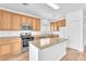 Bright kitchen featuring an island, wood cabinets, and stainless steel appliances at 5060 Blue Rose St, North Las Vegas, NV 89081