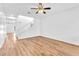 Spacious living room featuring hardwood floors, a ceiling fan, and staircase access at 5060 Blue Rose St, North Las Vegas, NV 89081
