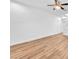 Spacious living room featuring hardwood floors, a ceiling fan, and staircase access at 5060 Blue Rose St, North Las Vegas, NV 89081