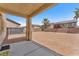 A covered patio space offers an outdoor living area with expansive gravel ground cover and partial perimeter fencing at 5060 Blue Rose St, North Las Vegas, NV 89081