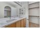 Modern bathroom featuring double sinks, marble countertops, and a walk-in closet at 5216 Aztec Heights St, North Las Vegas, NV 89081