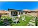 Lush backyard featuring artificial turf, stepping stones, a fire pit, and desert landscaping at 54 Mirage View Dr, Henderson, NV 89011