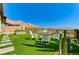 Inviting backyard with artificial turf, white Adirondack chairs, and mountain views at 54 Mirage View Dr, Henderson, NV 89011