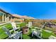 Stylish backyard features turf, desert landscaping, white Adirondack chairs, and a fire pit at 54 Mirage View Dr, Henderson, NV 89011