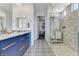 Modern bathroom featuring double sinks, designer tile flooring, and a glass enclosed shower at 54 Mirage View Dr, Henderson, NV 89011
