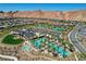 Aerial view of community pool, clubhouse, and palm trees in a meticulously landscaped desert setting at 54 Mirage View Dr, Henderson, NV 89011